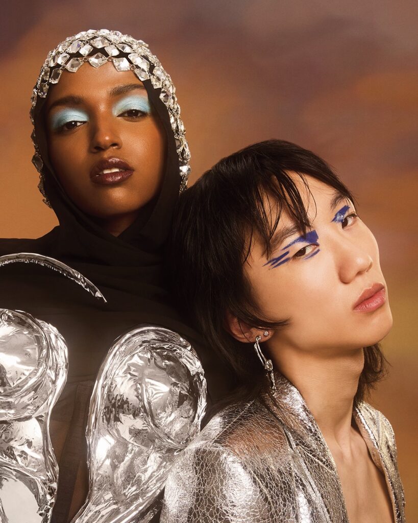 Beauty Awards Editorial shot black model with baby blue eye shadows and asian model graphic blue eye liner silver styling