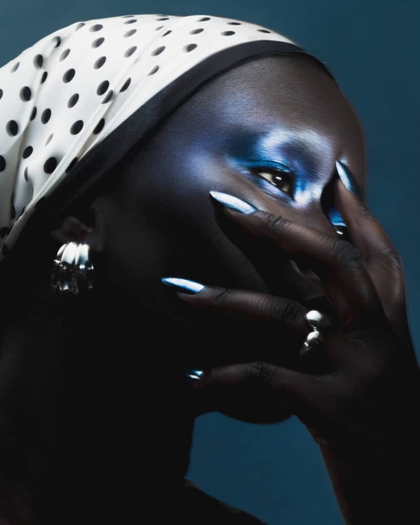 Creative beauty on dark skin model blue shadows and glossy lip by Robert Weir